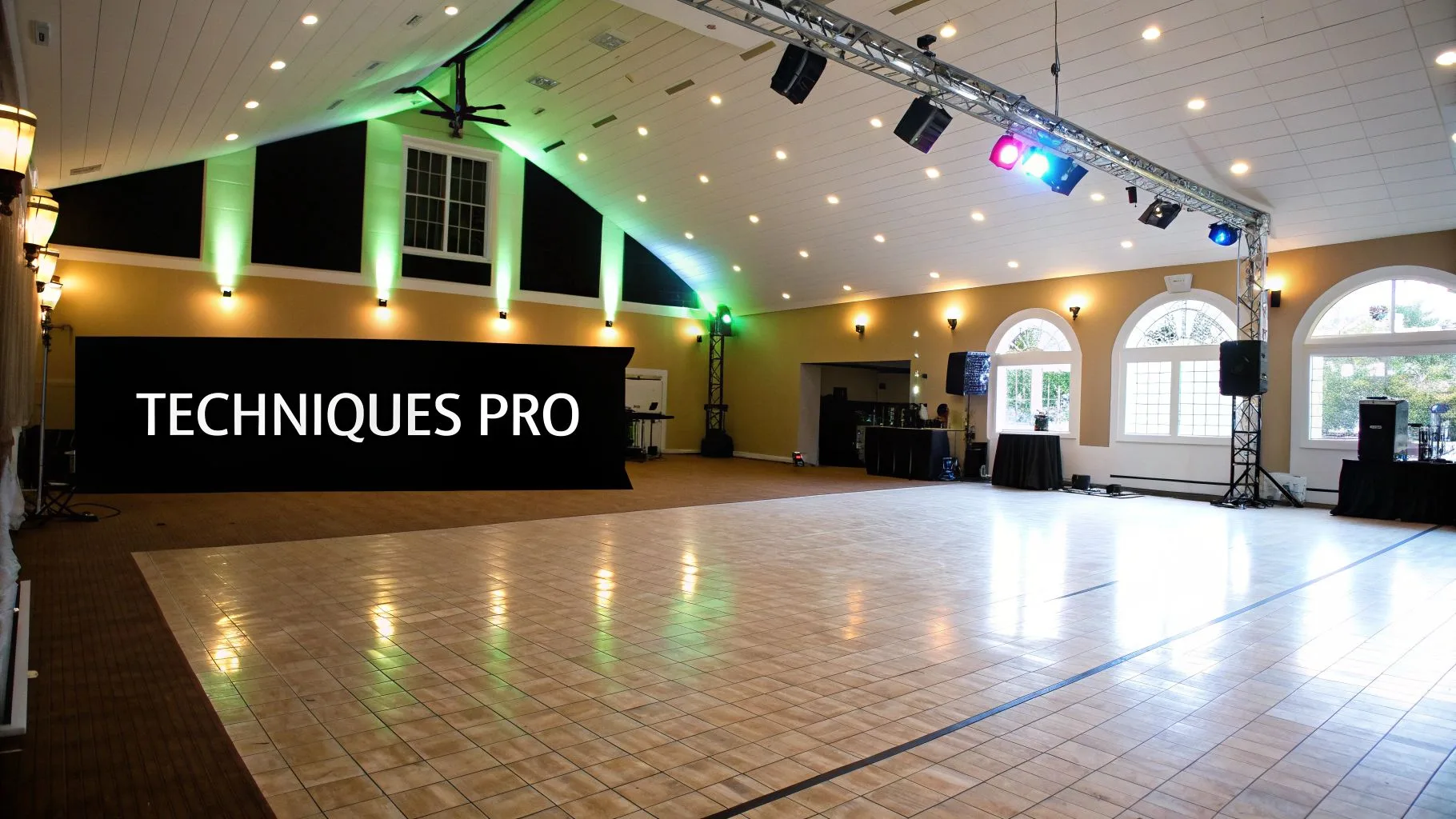 Salle de réception moderne avec piste de danse en bois, éclairages d'ambiance verts et équipement de sonorisation professionnel.